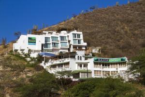 a white building on the side of a hill at Hotel Bahia Taganga in Taganga