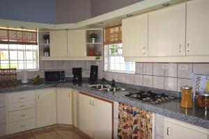 uma cozinha com armários brancos e bancadas em granito em 09 Casa De Presa em Kralendijk