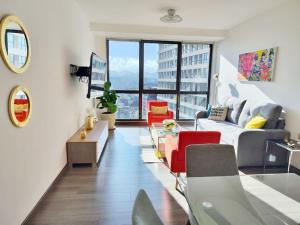 un soggiorno con divano e sedie rosse di Emilia MaiaHome-2BD Amazing view in Polanco -Pool Gym SPA a Città del Messico