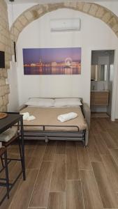a bedroom with a bed and a wooden floor at La casa degli innamorati in Bari