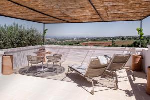 a patio with chairs and a table on a roof at Masseria Auraterrae in Polignano a Mare