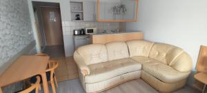 uma sala de estar com um sofá branco e uma cozinha em Alíz Apartman em Zalakaros