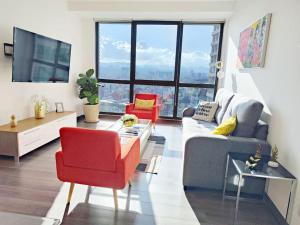 un soggiorno con un divano e una sedia rossa di Emilia MaiaHome-2BD Amazing view in Polanco -Pool Gym SPA a Città del Messico