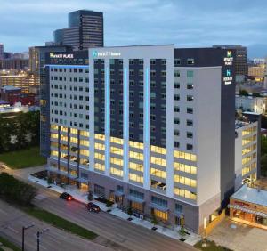 a large white building with lights on in a city at Hyatt House Houston Medical Center in Houston