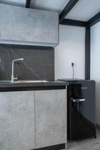 a kitchen with a sink and a black refrigerator at Casa de Castro - City Apartments in Thessaloniki +57 photos