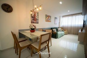 comedor y sala de estar con mesa y sillas en Lindo apartamento de 2 quartos no Cayenne, en João Pessoa