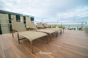 una fila de sillas sentadas en la parte superior de un balcón en Lindo apartamento de 2 quartos no Cayenne, en João Pessoa