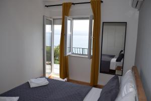 a bedroom with a bed and a view of a balcony at Apartman Oneum in Omiš