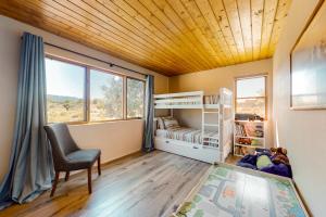 Casa Luna في Ranchos de Taos: غرفة نوم بسرير ومكتب وكرسي
