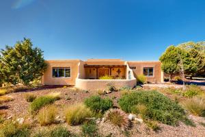 a house in the middle of a desert with trees at Casa Luna in Ranchos de Taos