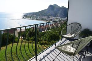 a balcony with chairs and a view of the ocean at Apartman Oneum in Omiš