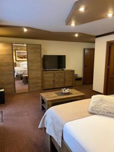 a hotel room with a bed and a flat screen tv at Apartament Darius in Moieciu de Sus