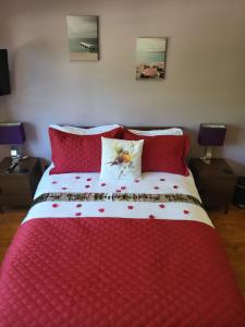 a red and white bed with red pillows on it at Little Robin Gate - Free Parking - Central - 10 min Walk to Train Station in Bournemouth