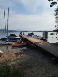 un muelle con barcos atracados sobre un cuerpo de agua en Mobilheim / Chalet, en Seekirchen am Wallersee