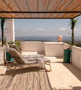 eine Terrasse mit einem Stuhl und Meerblick in der Unterkunft Masseria Auraterrae in Polignano a Mare