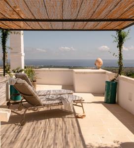 a patio with a chair and a view of the ocean at Masseria Auraterrae in Polignano a Mare