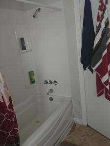 a bathroom with a shower and a white tub at Les Logements Larocque in Shippagan