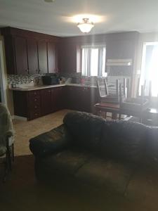 a living room with a couch and a kitchen at Les Logements Larocque in Shippagan