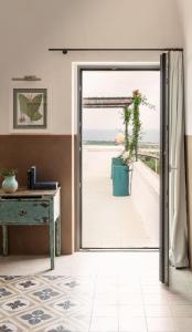 an open door with a view of the beach at Masseria Auraterrae in Polignano a Mare