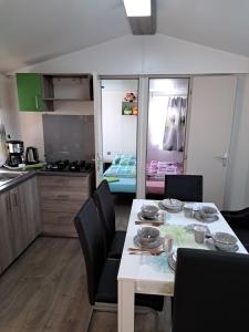 cocina y comedor con mesa y sillas en Mobilheim / Chalet, en Seekirchen am Wallersee