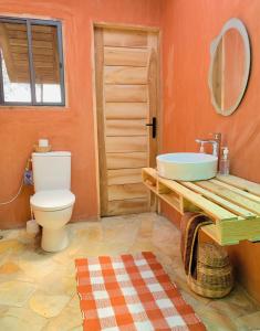 ein Bad mit einem WC und einem Waschbecken in der Unterkunft Glamping Lakeview Ouidah 