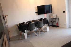 a black table with chairs and a television on a wall at Mediterranean Vista in Dubrovnik