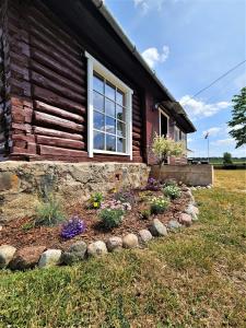 a house with a flower garden in front of it at Lauku māja Latgalē - ''Siguldas'' 