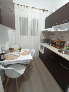 una pequeña cocina con mesa blanca y sillas en Helena's house, en Ermoupoli