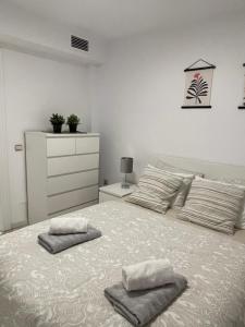 a bedroom with a large bed with two pillows on it at Jardines Apartment in Sitio de Calahonda