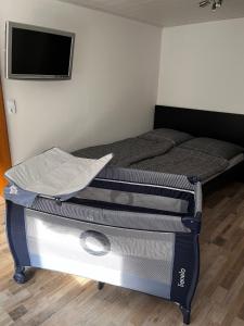 a bedroom with a bed and a flat screen tv at Weserbutze in Bodenwerder