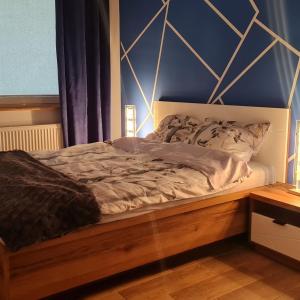 un letto con struttura in legno in una stanza di Apartament z wodą termalną a Uniejow