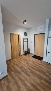 una stanza vuota con due porte e un pavimento in legno di Apartament z wodą termalną a Uniejow