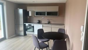 a kitchen with a table and chairs and a refrigerator at Moderne Leilighet med panorama utsikt check -In 24 h in Sandefjord