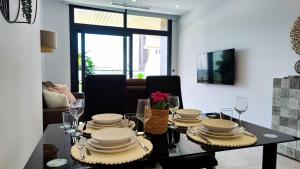 uma mesa de jantar com pratos e taças de vinho em SUNSET WAVES relax apartment em Benidorm