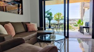 uma sala de estar com um sofá e uma mesa em SUNSET WAVES relax apartment em Benidorm