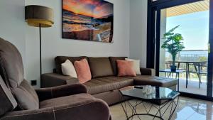 uma sala de estar com um sofá e uma mesa em SUNSET WAVES relax apartment em Benidorm