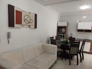 sala de estar con sofá blanco y mesa en Apartamento novo 450 mt da praia Ingleses, en Florianópolis