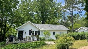 a white house with a porch and a yard at Lake Perch in Lakeside