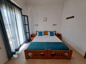a bedroom with a large bed with blue pillows at Apollonia Apartments in Agia Pelagia