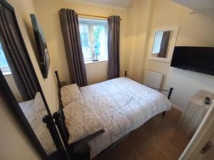 a small bedroom with a bed and a window at Eastfield cottages in Devizes