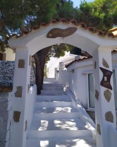 an archway with a white building with a tree at Kocheilas Studios in Gialiskari
