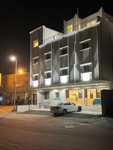 une voiture garée devant un bâtiment la nuit dans l'établissement مساكن الراحة, à Abha