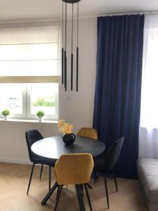 a dining room with a black table and chairs at Apartament Miło Mi Gdynia Centrum in Gdynia