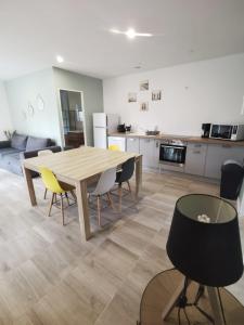 Il comprend une cuisine et une salle à manger avec une table et des chaises en bois. dans l'établissement Logement 5 kms de Berck plage, à Verton