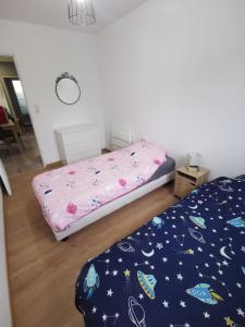 a bedroom with a bed with a comforter on it at Logement 5 kms de Berck plage in Verton