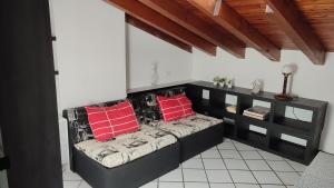 a room with a bench with red pillows on it at Residence Il Cantiere in Predore