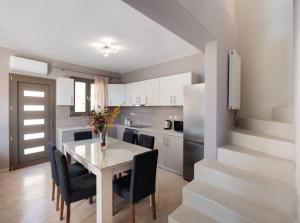 a kitchen with a table and chairs and a staircase at Villa Sofia in Póndi