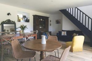 a living room with a table and chairs and a staircase at Escale de Gerbold in Gratot