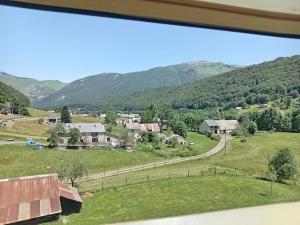 a view of a farm with mountains in the background at Appartement vallée de Campan in Campan