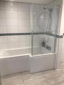 a bathroom with a shower and a white bath tub at Beachside Mews in Broadstairs